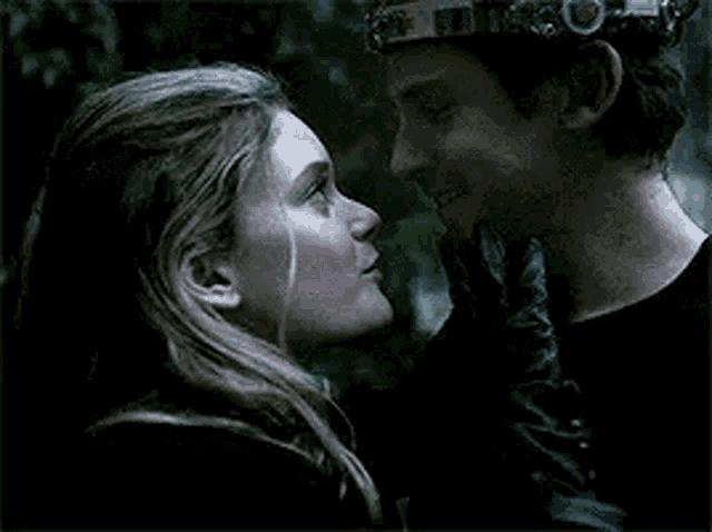 a man and a woman are kissing each other in a dark room .