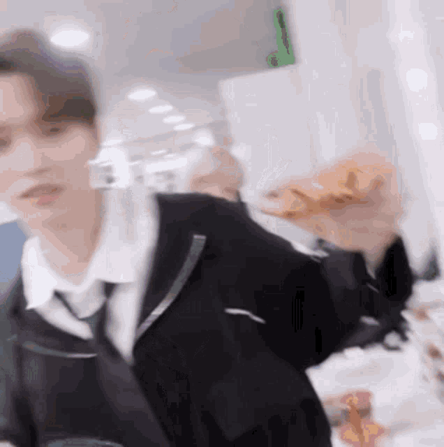 a blurry picture of a man in a suit and tie holding a croissant .