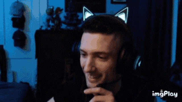a man wearing a headset with cat ears on it is smiling .