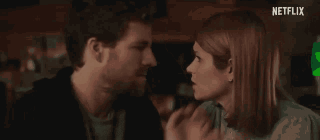a man and a woman are looking at each other in a bar .