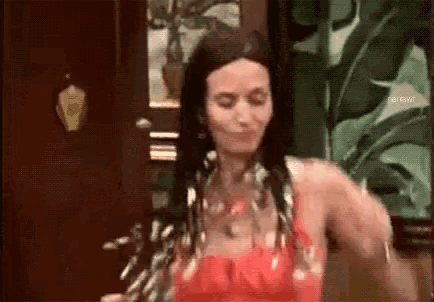 a woman in a red dress is standing in a room