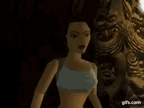 a woman in a blue tank top is standing in a dark room .