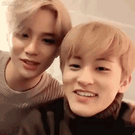 two young men are posing for a picture together and smiling .