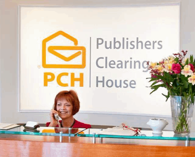 a woman talking on a phone in front of a pch clearing house sign