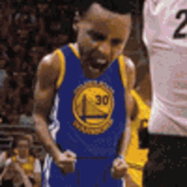 a basketball player wearing a golden state warriors jersey is yelling at another player on the court .