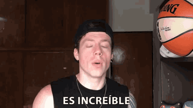 a man wearing a hat and a black tank top says es increible