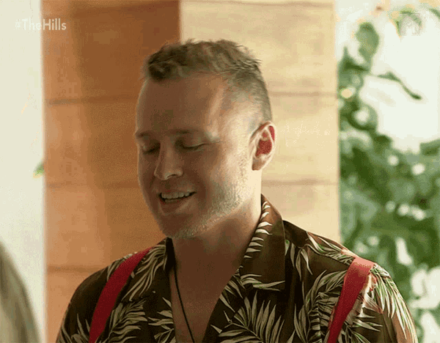 a man wearing a hawaiian shirt is smiling with the hills written on the bottom