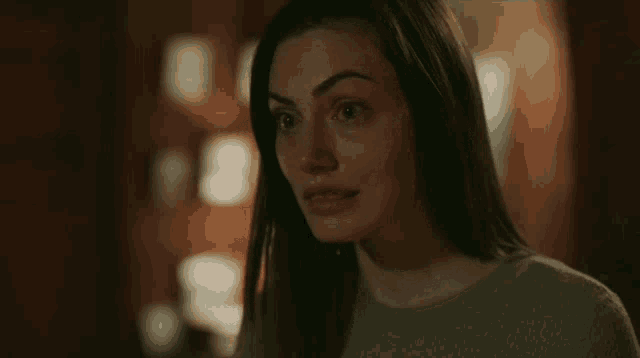 a close up of a woman 's face in a dark room .
