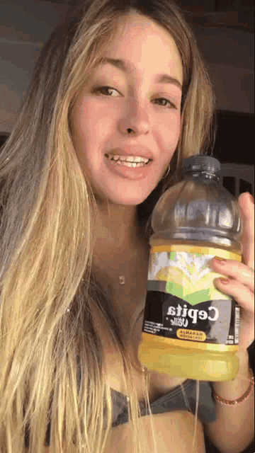 a woman in a bikini is holding a bottle that says ' cobit ' on it
