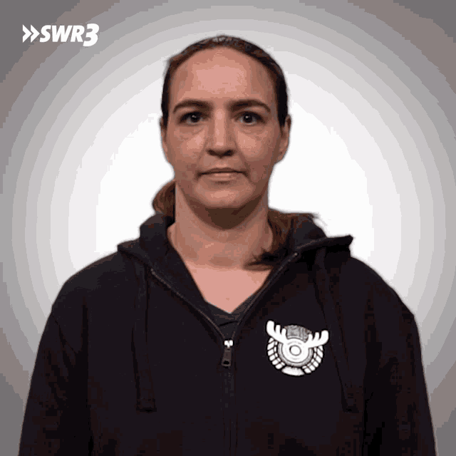 a woman wearing a black hoodie with a moose logo on the front