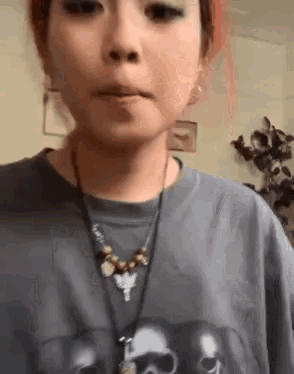 a girl wearing a necklace and a t-shirt with skulls on it