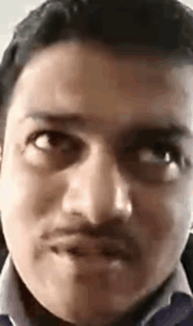 a close up of a man 's face with a mustache making a face .