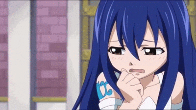 a girl with blue hair and a tattoo on her arm is looking at the camera .