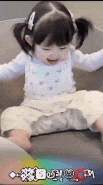 a little girl is sitting on a couch with a rainbow colored background that says doyou