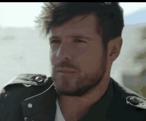 a man with a beard wearing a black jacket