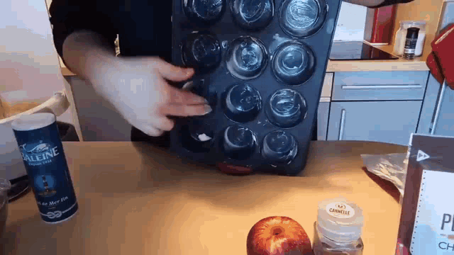 a can of paleine sits on a kitchen counter next to an apple
