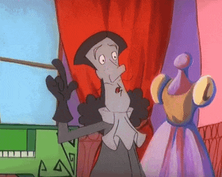 a cartoon character is standing in front of a red curtain and giving a thumbs up .