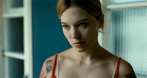a woman with a tattoo on her arm is looking out of a window