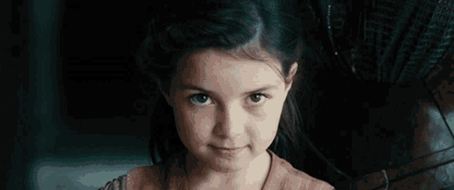 a close up of a little girl 's face with a serious look on her face