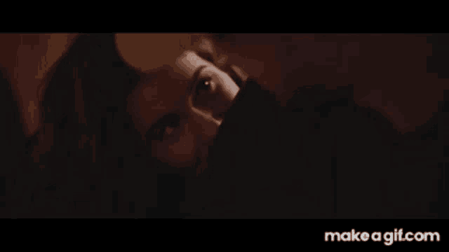 a man and a woman are kissing each other in a dark room .