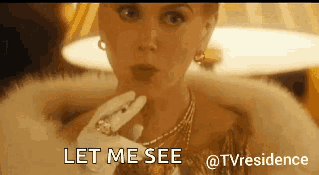 a woman in a fur coat and gloves says " let me see "