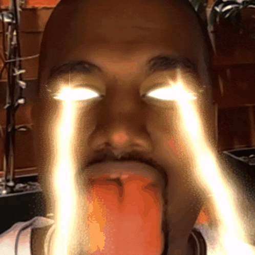 a close up of a man 's face with his eyes glowing brightly