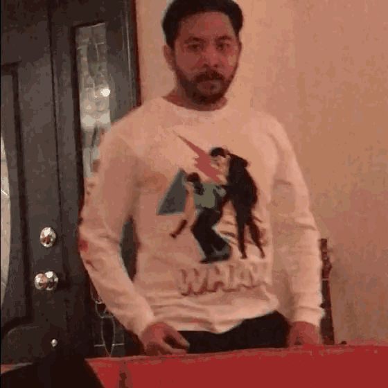 a man with a beard wears a white shirt that says what
