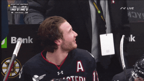 two hockey players are smiling in front of a td bank sign