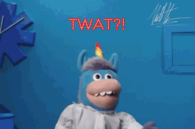 a stuffed animal with a unicorn horn and the word twat on it