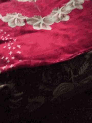 a close up of a red cloth with flowers and stars on it