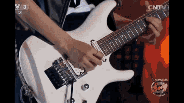 a person playing a guitar with cntv on the bottom left