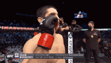 a man wearing boxing gloves is standing in front of a ufc sign