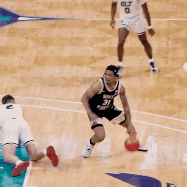 a basketball player with the number 31 on his jersey tries to block another player