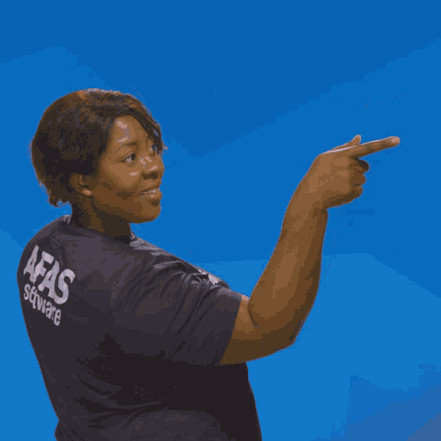 a woman wearing a shirt that says afas software is pointing