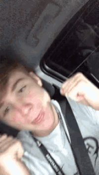 a young man is taking a selfie in a car while wearing a lanyard that says montana