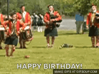 a group of people in kilts are playing bagpipes in a field and dancing .