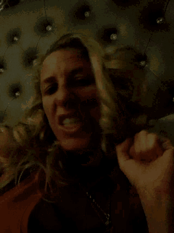 a woman laying on a bed with her mouth open and a hand on her face