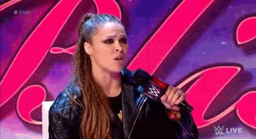 a woman is sitting in front of a microphone on a stage .