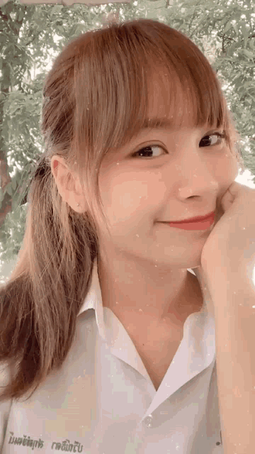 a girl in a white shirt with a name tag on her chest is smiling