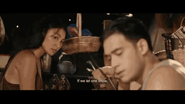 a man and a woman are sitting next to each other in a room .