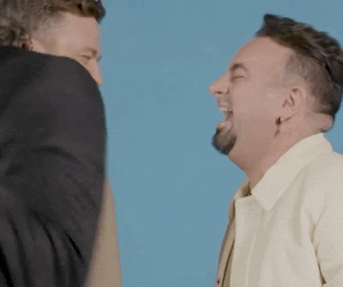 two men are laughing and hugging each other