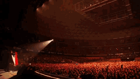 a large crowd of people in a stadium watching a concert sponsored by coca cola