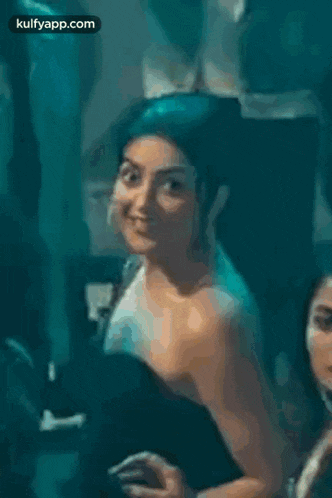 a woman in a yellow off the shoulder top is smiling and looking at the camera .