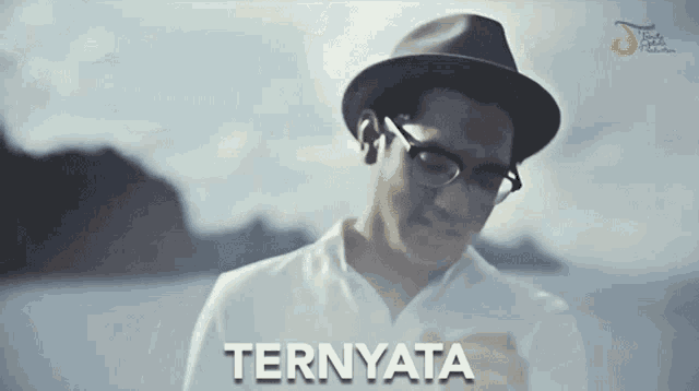 a man wearing glasses and a hat with the word ternyata written on the bottom