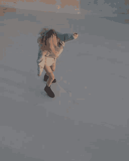 a woman in a grey shirt and black boots is jumping in the air