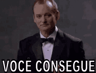 a man in a tuxedo and bow tie is giving a speech .
