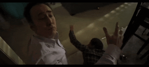 a man in a white shirt is laying on the ground in a room .