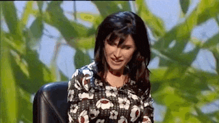 a woman is sitting in a chair on a stage .