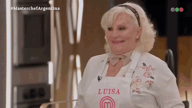 a woman wearing a white shirt and a white apron with the name luisa on it