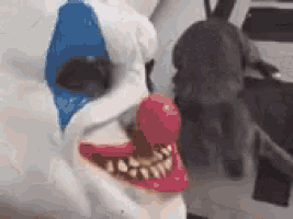 a close up of a clown 's face with a red nose and teeth .